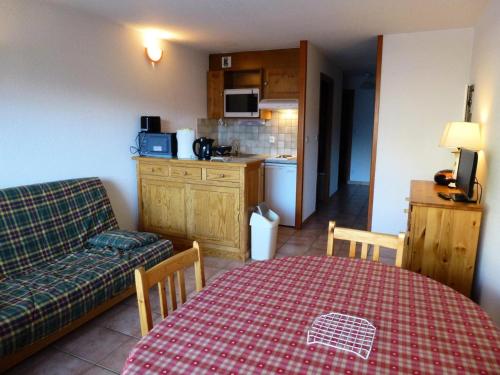 salon ze stołem i kanapą oraz kuchnia w obiekcie Résidence Les Balcons Des Curtious - 2 Pièces pour 6 Personnes MAE-2313 w mieście Bessans