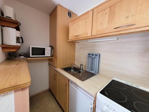 a small kitchen with a sink and a microwave at Résidence Belle - 2 Pièces pour 4 Personnes MAE-2353 in Lanslevillard
