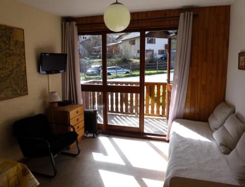 a bedroom with a sliding glass door with a balcony at Résidence Belle - 2 Pièces pour 4 Personnes MAE-2353 in Lanslevillard