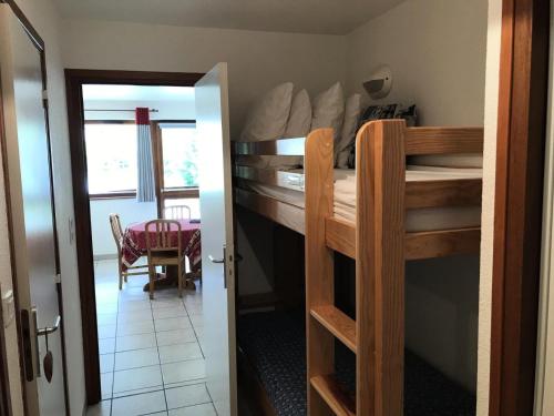 a room with two bunk beds and a dining room at Résidence Les Balcons Des Curtious - Studio pour 4 Personnes MAE-2363 in Bessans