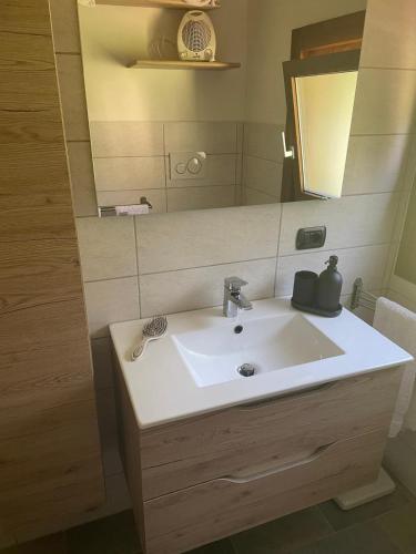 a bathroom with a sink and a mirror at Mansarda Cadore in Pieve di Cadore