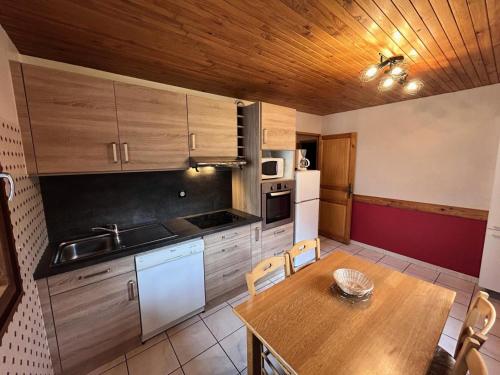 a kitchen with a wooden table and a wooden ceiling at Résidence Andagne - Appartement spacieux bien situé MAE-2423 in Bessans