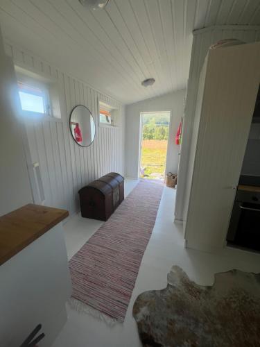 a hallway with a room with a couch and a window at Charming place in Tromsø by the sea. in Håkøybotn