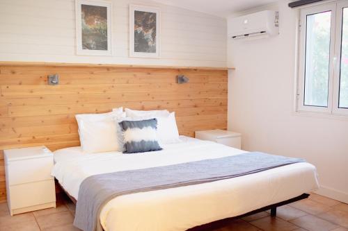 a bedroom with a large bed with a wooden wall at Onda - Boutique Garden Ocean View Suite in the Countryside - Vila Pilar in Pilar