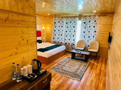 a bedroom with a bed and a table and chairs at Sabr resorts in Pahalgām