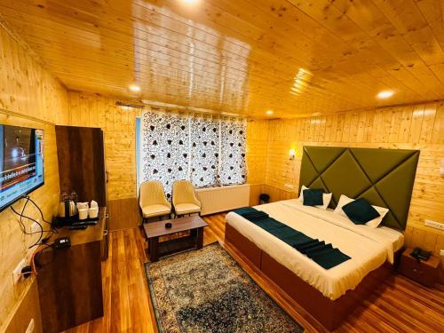 a bedroom with a bed and a television in a room at Sabr resorts in Pahalgām