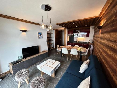 a living room with a blue couch and a table at Résidence La Bergerie - Appartement 2 pièces chaleureux et bien équipé MAE-2433 in Bonneval-sur-Arc