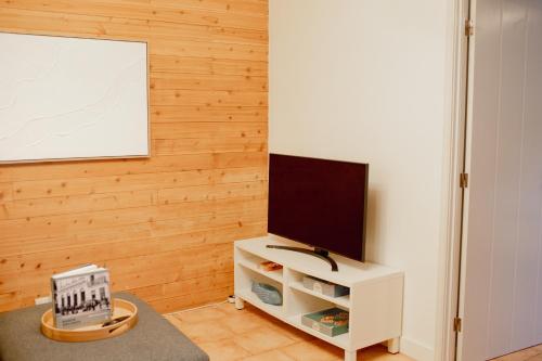 a living room with a flat screen tv on a cabinet at Onda - Boutique Garden Ocean View Suite in the Countryside - Vila Pilar in Pilar