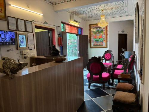 a lobby with a bar with pink chairs in it at Hotel Kanak Niwas in Bedla