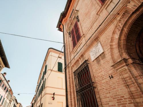 a tall brick building with a gate on the side of it at Hotel Lory in Forlì