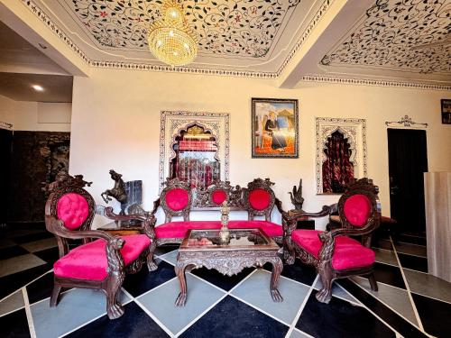 a living room with pink furniture and a ceiling at Hotel Kanak Niwas in Bedla