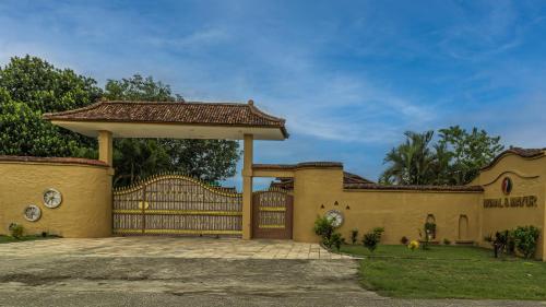 a house with a gate and a fence at Munal and Mayur Resort - Wellness Retreat Pvt Ltd in Tikoli