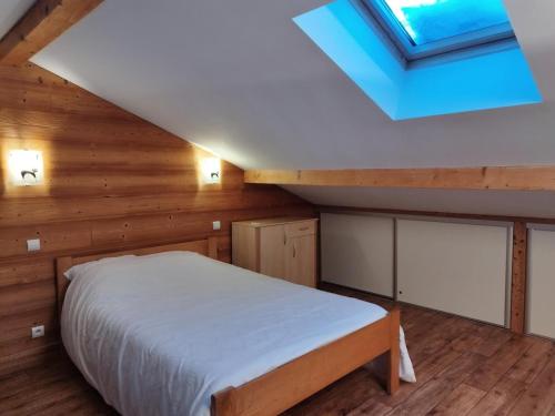 a bedroom with a bed and a skylight at Résidence Lanslevillard Quartier Eglise - Le Flocon des Bois MAE-2503 in Lanslevillard