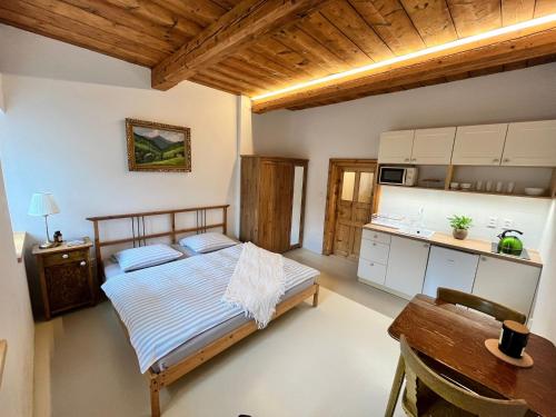 ペツ・ポト・スニェシュコウにあるApartmány Bouda 230のベッドとテーブルとキッチンのある寝室