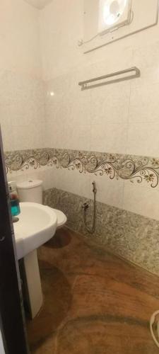 a bathroom with a white sink and a toilet at Hotel Kanak Niwas in Bedla