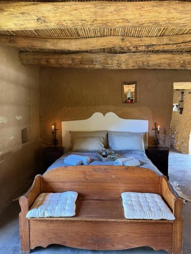a bedroom with a large wooden bed with two pillows at Klipkraal Cottage in Calitzdorp