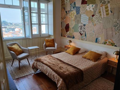 a bedroom with a bed and two chairs at AL Marias de Órion in Coimbra