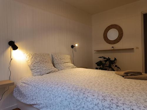 ルーアンにあるHypercenter apartmentの白い掛け布団と鏡が付いたベッドのある寝室