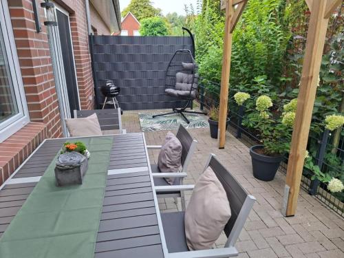 a patio with a table and chairs with pillows on it at NEU! Ferienhaus Time-out in Weener