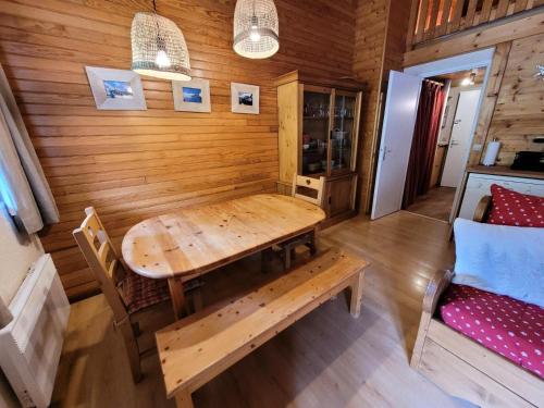 a wooden dining room with a table and a bench at Résidence Tralenta DispersÉ - Studio mezzanine cosy et chaleureux MAE-2643 in Bonneval-sur-Arc