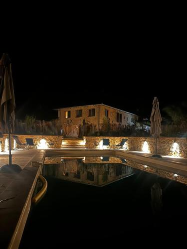 a swimming pool at night with a building in the background at Le Rivalou - Chambres d'hôtes - Grazac - Tarn in Grazac
