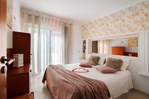 a bedroom with a large bed with a large window at Casa Vista Mar in Albufeira