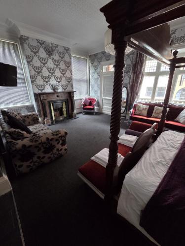 a bedroom with a canopy bed and a fireplace at The White Hart Hull in Hull