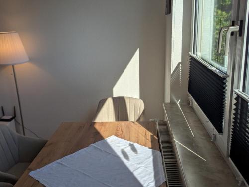 Una mesa de madera en una habitación con una lámpara y una silla. en City Apartment - Heinrich der Löwe - City Center - Keybox - 3 Persons, en Brunswick
