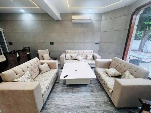 a living room with couches and a table in a room at Ambar villa in Mohali