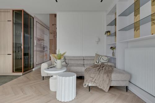 ein Wohnzimmer mit Sofa und Tisch in der Unterkunft Porto Letnica Apartments with Gym & Parking by Lion Apartments in Danzig