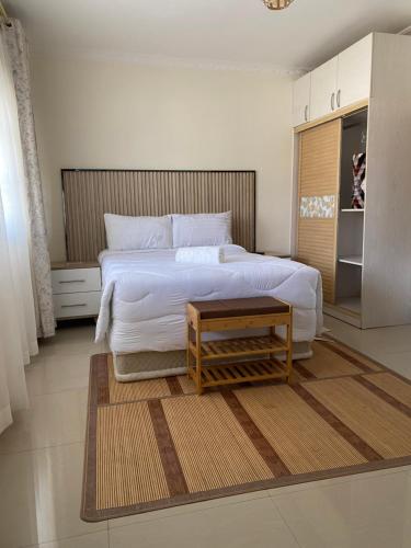 a bedroom with a large white bed and a table at Lelesha Lodge Makeni in Lusaka