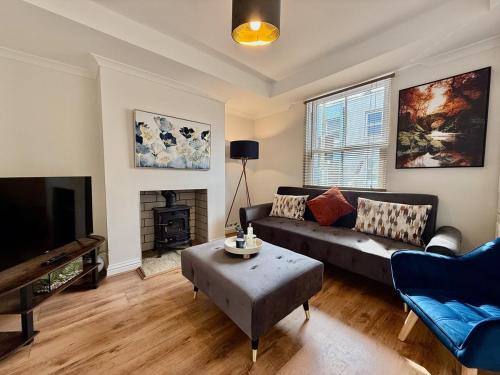 a living room with a couch and a tv at Private 2BR house, Cheltenham Centre & Parking in Cheltenham