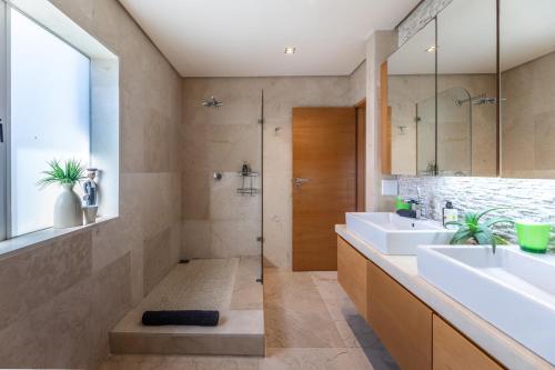 Un baño con dos lavabos y una ducha. en Dolphin View Cabana Beach House, en Cape Town