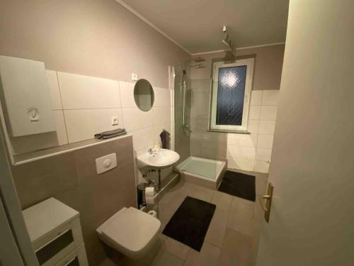 a bathroom with a toilet and a sink at Ferien- & Monteurwohnung zentral Übach-Palenberg 1 in Übach-Palenberg