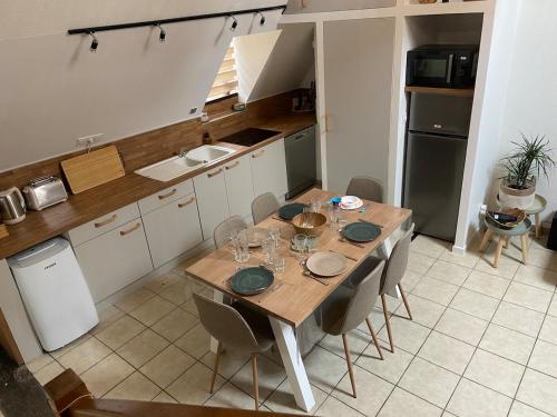 a kitchen with a wooden table and chairs in a kitchen at Bali Surya in Chalon-sur-Saône