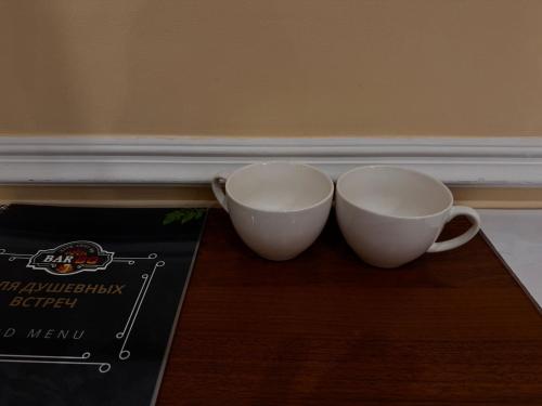 two white cups sitting on a table next to a box at Sky luxe-hotel Astana in Astana