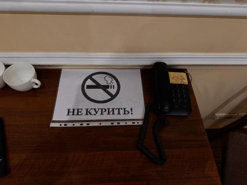 a phone on a table with a no smoking sign at Sky luxe-hotel Astana in Astana