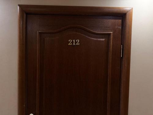 a wooden door with the number on it at Sky luxe-hotel Astana in Astana