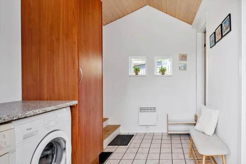 a laundry room with a washing machine and a chair at 30383-Odder-Lyngbakkevej-10 in Odder