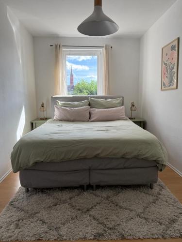 a bedroom with a large bed with a window at Wohnen am Main in Würzburg