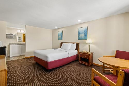 a hotel room with a bed and a table at Americas Best Value Inn Biddeford in Biddeford