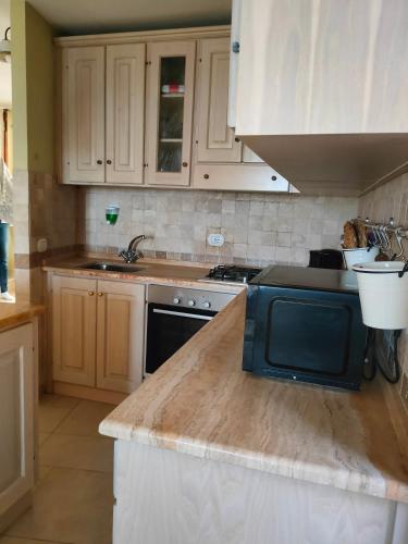 a kitchen with white cabinets and a counter top at Ciliano 16 in Montepulciano