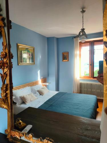 a blue bedroom with a bed and a mirror at Ciliano 16 in Montepulciano
