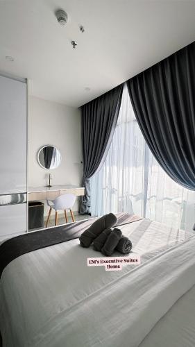a bedroom with a large bed with a large window at The Shore Kota Kinabalu by Ems Executive Suites Seaview in Kota Kinabalu