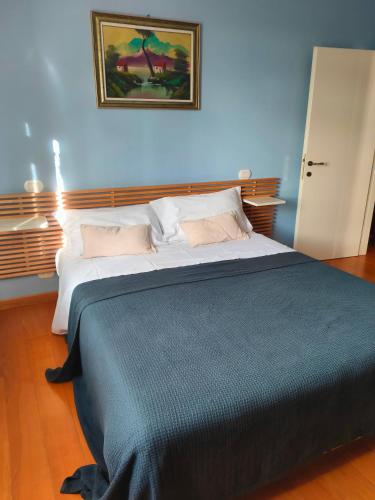 a large bed in a bedroom with a blue wall at Ciliano 16 in Montepulciano