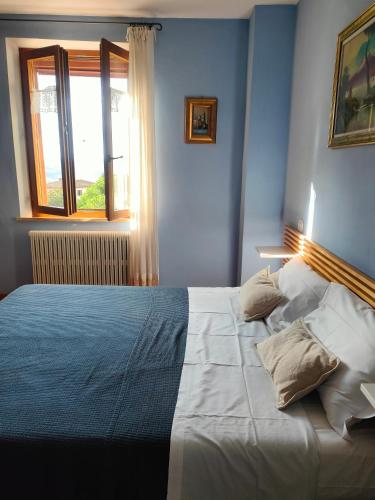 a bedroom with a large white bed with a window at Ciliano 16 in Montepulciano