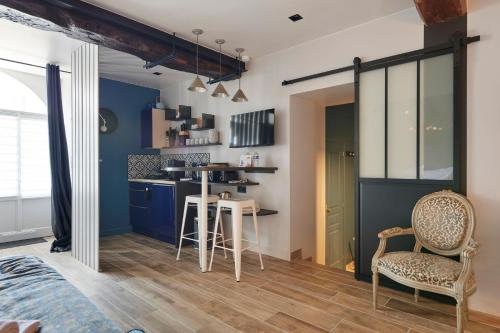 a kitchen with blue cabinets and a table and chairs at L'Echoppe - Charmant studio au cœur de Clisson in Clisson