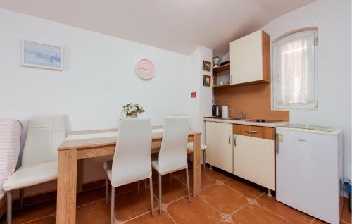 a kitchen with a wooden table and white cabinets at Awesome Apartment In Karlobag With Wifi in Karlobag