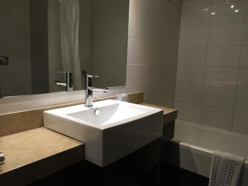 a bathroom with a white sink and a bath tub at Crystal Tower in Montevideo