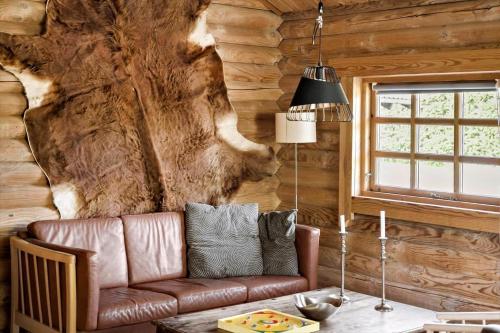 a living room with a leather couch in a log cabin at 30118-Odder-Pouli-Nielsensvej-27 in Beder
